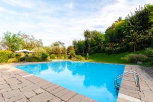 a swimming pool with blue water in a yard at Bagode Country Lodge in Desenzano del Garda