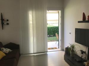 een woonkamer met een deur naar een patio bij Villaggio Michelangelo in Bibione