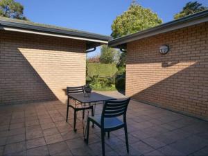 a patio with two chairs and a table on a brick wall at Forest and Ferns in Graskop +3 photos