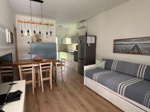 een woonkamer en keuken met een bank en een tafel bij Villaggio Michelangelo in Bibione