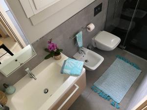 a small bathroom with a sink and a toilet at Villaggio Michelangelo in Bibione +27 photos