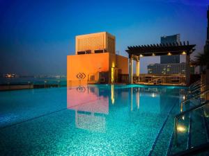 a swimming pool on top of a building at night at Sofitel Dubai Jumeirah Beach in Dubai