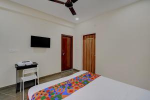 a bedroom with a bed and a desk and a television at FabHotel Heaven 75 in Hyderabad