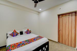 a bedroom with a bed and a wooden door at FabHotel Heaven 75 in Hyderabad