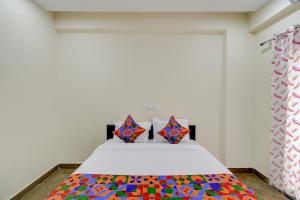 a bedroom with a bed with a colorful blanket on it at FabHotel Heaven 75 in Hyderabad +25 photos