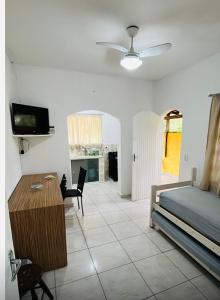 een slaapkamer met een bed, een tafel en een tv bij Chalés Boraceia Duda in Boracéia