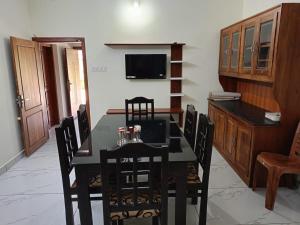 een eetkamer met een zwarte tafel en stoelen bij Valley De Hills Farm Villa in Attappādi
