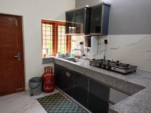 een keuken met een spoelbak en een aanrechtblad bij Valley De Hills Farm Villa in Attappādi