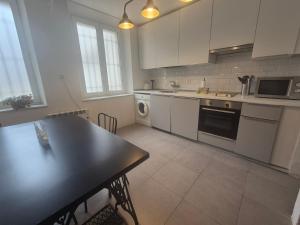 Una cocina con gabinetes blancos y una encimera negra. en 659A by R2R Apartmento céntrico para 3 personas, en Oviedo