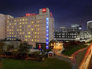 a tall building with lights on it in a city at ibis Gurgaon Golf Course Road - An Accor Brand in Gurgaon
