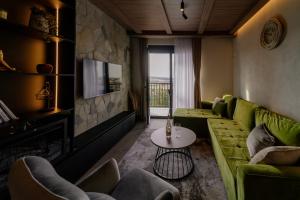 a living room with a green couch and a tv at Zlatibor Pine & Peak in Zlatibor