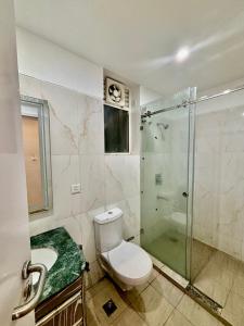 a bathroom with a toilet and a glass shower at The Amerin Inn & Suites , Gomti Nagar Lucknow in Lucknow