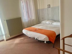 a bedroom with a large bed with an orange blanket at Albergo Casa Sperti in Spert