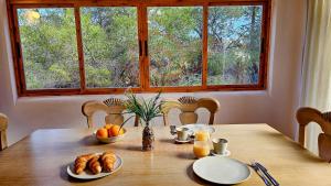une table avec du pain et un vase d'oranges dessus dans l'établissement Bungalow Almendros by Live It, à Moraira