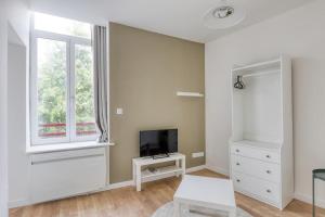 a white bedroom with a tv and a window at Azur 2 - Gare de Roubaix in Roubaix
