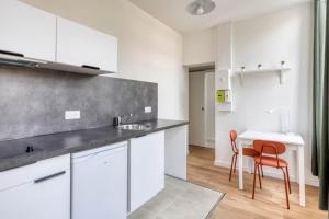 a kitchen with white cabinets and a table and chairs at Azur 2 - Gare de Roubaix in Roubaix