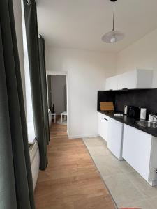 a kitchen with white cabinets and a counter top at Azur 2 - Gare de Roubaix in Roubaix