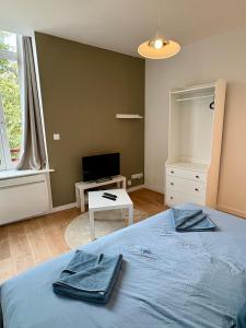 a bedroom with a blue bed and a television at Azur 2 - Gare de Roubaix in Roubaix