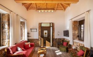 a living room with a red couch and a fireplace at Seaside Stone Retreat in Salamina