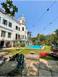 a large building with a swimming pool in front of it at Castelo dos Tucanos Host in Rio de Janeiro