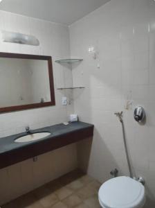 a bathroom with a sink and a toilet and a mirror at Portobello in Porto Seguro