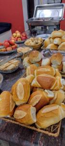 un tavolo con sopra cestini di pane e mele di Hotel Chalé Centro a Curvelo