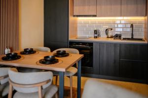 a kitchen with two tables and chairs and a stove at Zlatibor Pine & Peak in Zlatibor