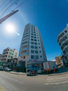 a tall white building on a city street at Cosy 1 Bedroom in CBD Mombasa with City View in Mombasa