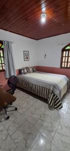 Posto letto in camera con scrivania e sedia. di Casa Flor 2- Centro vista p o Rio a Nova Friburgo