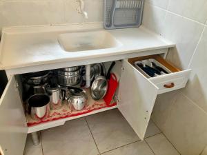 a white cabinet with a sink and some pots and pans at Residencial Camirys in Itapoa +9 photos