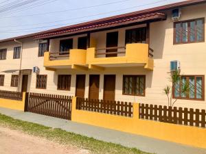 a yellow house with a fence in front of it at Residencial Camirys in Itapoa