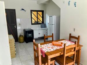 a kitchen with a table and a refrigerator at Residencial Camirys in Itapoa