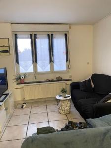 un salon avec un canapé et une fenêtre dans l'établissement Maison ou chambres a louez, à Armentières