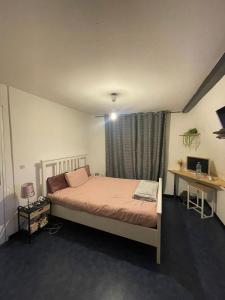 une chambre avec un lit, un bureau et une fenêtre dans l'établissement Maison ou chambres a louez, à Armentières