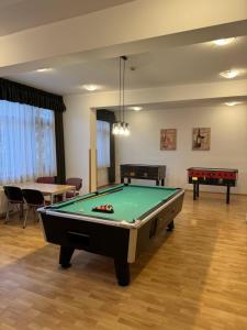 een woonkamer met een pooltafel en 2 tafels bij Thermal Hotel Tengelic 