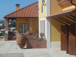 a house with two large pots in front of it at Casa Agricola Quinta Da Junqueira in Reguengo Grande