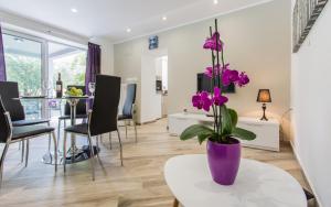 a living room with a purple vase with purple flowers on a table at Sunrise Apartment Risika in Risika