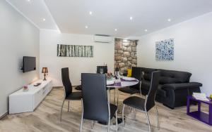 een woonkamer met een tafel, stoelen en een bank bij Sunrise Apartment Risika in Risika