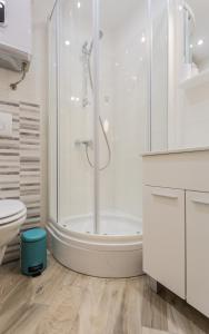 een witte badkamer met een douche en een toilet bij Sunrise Apartment Risika in Risika +27 foto's