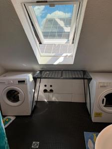 eine Waschküche mit Fenster und Waschmaschine in der Unterkunft GMA Apartment H26 in Mahlberg