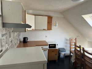 eine Küche im Dachgeschoss mit weißen Schränken und einem Herd in der Unterkunft GMA Apartment H26 in Mahlberg + 17 Fotos