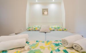 een wit bed met kussens erop bij Sunrise Apartment Risika in Risika