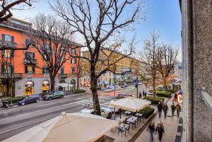 eine Gruppe von Menschen, die eine Stadtstraße mit Sonnenschirmen entlanglaufen in der Unterkunft Center of Bergamo BGYnn Le Grazie in Bergamo
