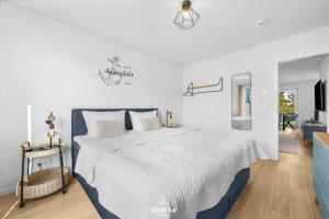 a white bedroom with a large bed in a room at Strandgeflüster in Olpenitz