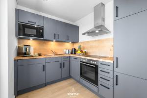 a kitchen with blue cabinets and a sink and a microwave at Strandgeflüster in Olpenitz
