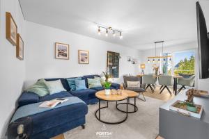 a living room with a blue couch and a table at Strandgeflüster in Olpenitz