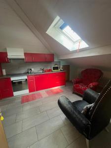 eine Küche mit roten Schränken und einem Sofa in einem Zimmer in der Unterkunft Casa Pesa - Olivone in Olivone