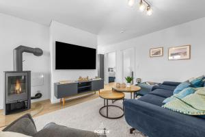 a living room with a blue couch and a fireplace at Strandgeflüster in Olpenitz
