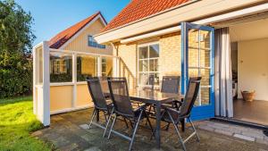 een tafel en stoelen op het terras van een huis bij De Lepelaer in Schoorl