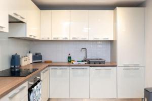 eine weiße Küche mit weißen Schränken und einer Spüle in der Unterkunft Nr 8 - Modern 2 Bed Flat - WiFi - Town Centre - Parking in Bedford